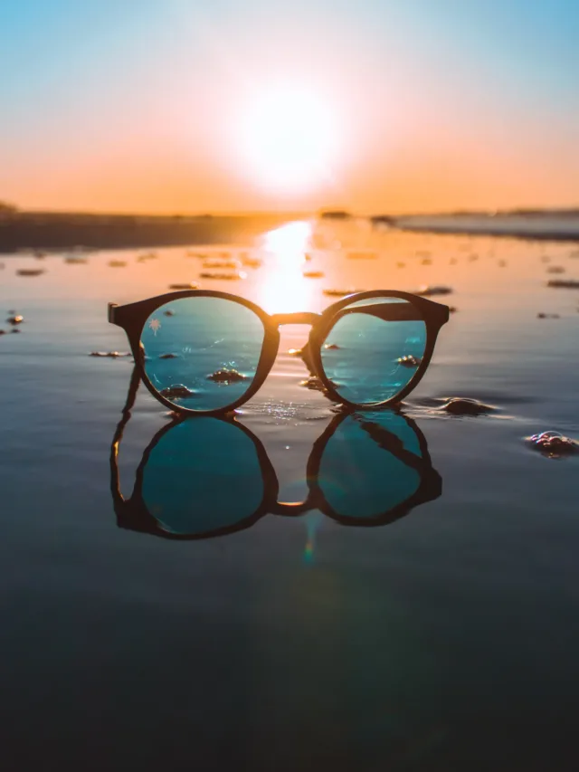 A pair of sunglasses on a beach backdrop